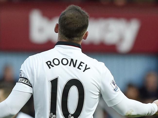 Referee Mark Calattenburg gestures as he speaks with Manchester United’s Wayne Rooney during the English Premier League soccer match between West Ham United and Manchester United at the Boleyn Ground in London, Sunday, Feb. 8, 2015. (AP Photo/Alastair Grant)