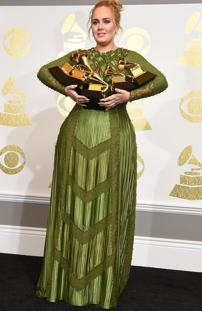 Adele poses in the press room with her trophies in her green Grammys dress.