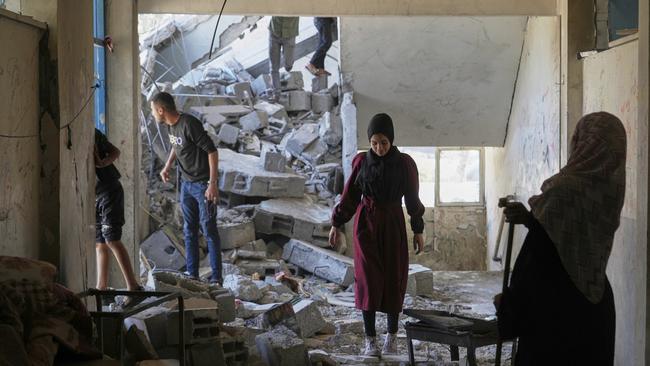 Palestinians inspect the damage at a school used as a shelter by displaced residents that was hit twice by Israeli army strikes. Picture; AP.