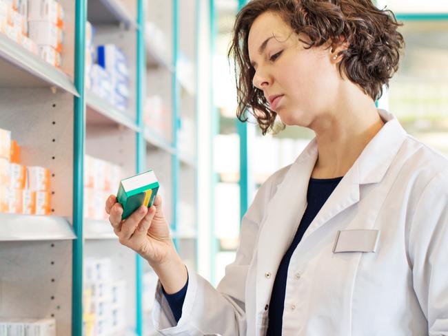 Generic photo of a pharmacist taking medicine from shelf at a  pharmacy. Picture: iStock