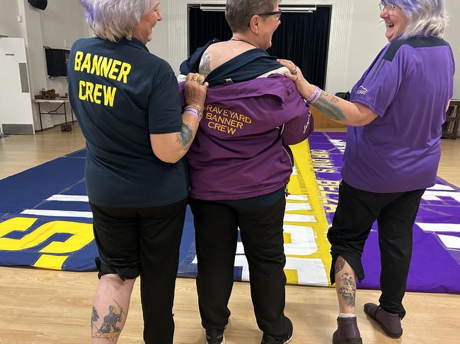 Melbourne Storm banner crew members Linda Hutchins, Sue Levy and Wendy Gillam show off their Storm tattoos. Picture: Shannon Gill