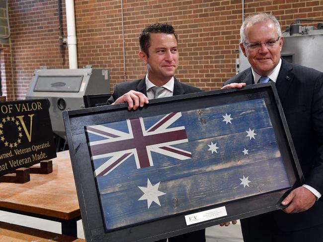 Prime Minister Scott Morrison is presented with a woodcut of the Australian flag at the Bunker Lab program in Alexandria in Washington DC. Picture: AAP