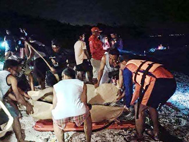 Coast guard personnel and rescuers place the recovered bodies of two Russian divers on stretchers near Verde Island, in Batangas City, south of Manila. Picture: Philippine Coast Guard / AFP