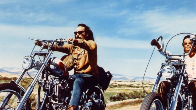 An artist’s impression of ALP returning officer Terry Wood on the road to Mackay, secret ballots in his backpack. (Chooks apologises to Easy Rider.)