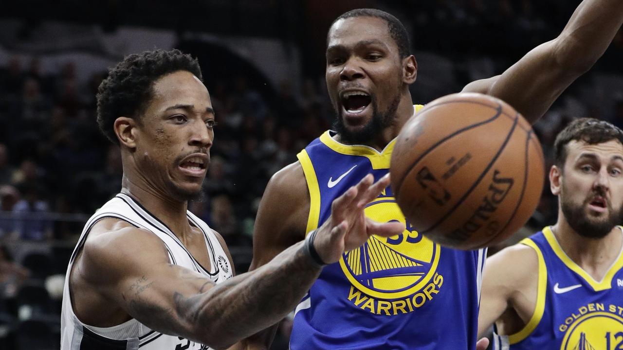 San Antonio Spurs guard DeMar DeRozan (10) passes the ball around Golden State Warriors forward Kevin Durant (35)