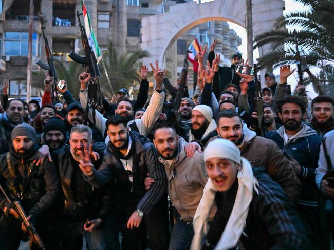 Local residents cheer as the gather on a street in the Damascus suburb of Jaramana on December 8. Syrian rebels said President Bashar al-Assad had fled the country, calling on citizens abroad to return to a "free Syria" and saying that Damascus was free of the "tyrant". Picture: Louai Beshara/AFP