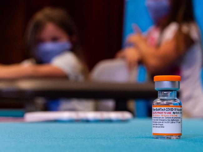 A vial of the new children's dose of the Pfizer-BioNTech Covid-19 vaccine as children wait to receive the vaccine Picture: AFP.