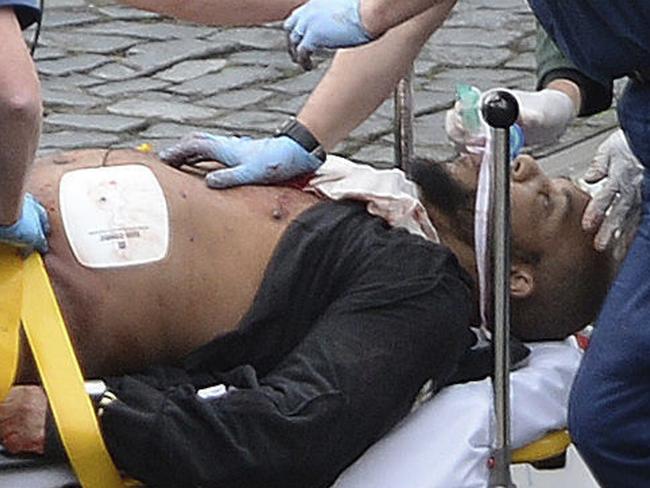 London attacker Khalid Masood is treated by emergency services outside the Houses of Parliament. Picture: AP