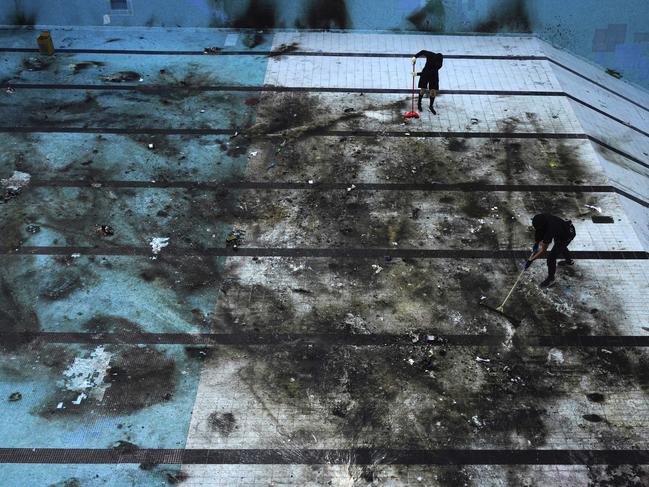 A university swimming pool is cleaned after being damaged in protests. Picture: AP