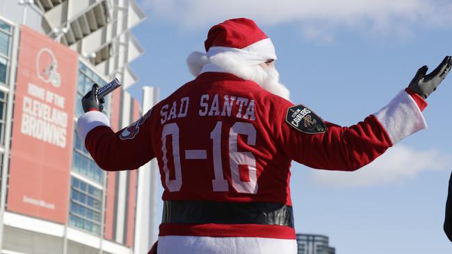 A Cleveland Browns fan dressed as Santa Claus participates in the "Perfect Season" parade.
