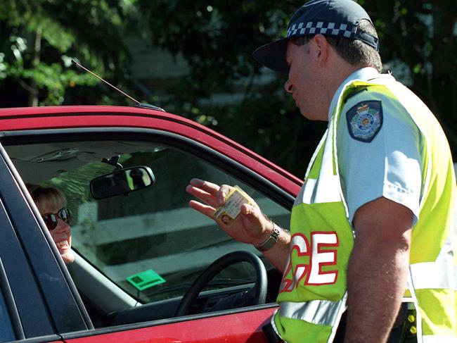 Pic Nathan/Richter 01 jun 1999 Police enforce 50km speed limit Sgt Peter Flanders checks Leigh Muirhead's licence as she was caught speeding in Paddington. qld law offence