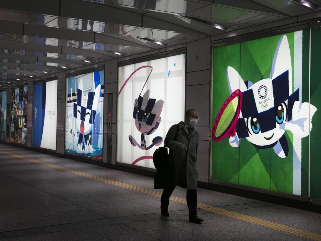 A man walks past large adverts promoting the Tokyo 2020 Olympics