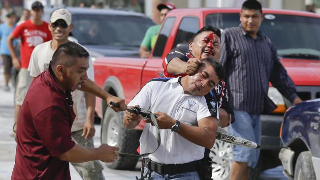 A man (pictured in white) tries to stop looters from storming into the Mega Supermarket.