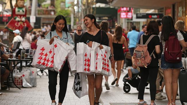 Student Jiaqi Yu, left, helps carry fellow student Yufei Ding’s many bags of Boxing Day sales purchases, in the Queen Street Mall in Brisbane. Picture: Lyndon Mechielsen/The Australian