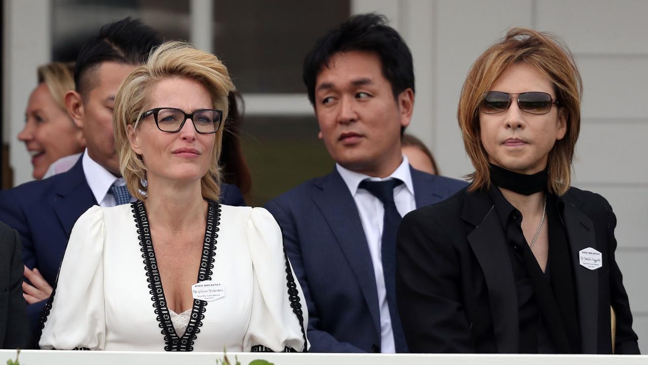 Gillian Anderson (left) and Yoshiki. At least he can say his scarf met the Queen. Picture: Steve Parsons/PA Wire