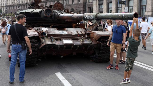 A young child hangs off the barrel of a tank on display in Kyiv. Picture: Liam Mendes