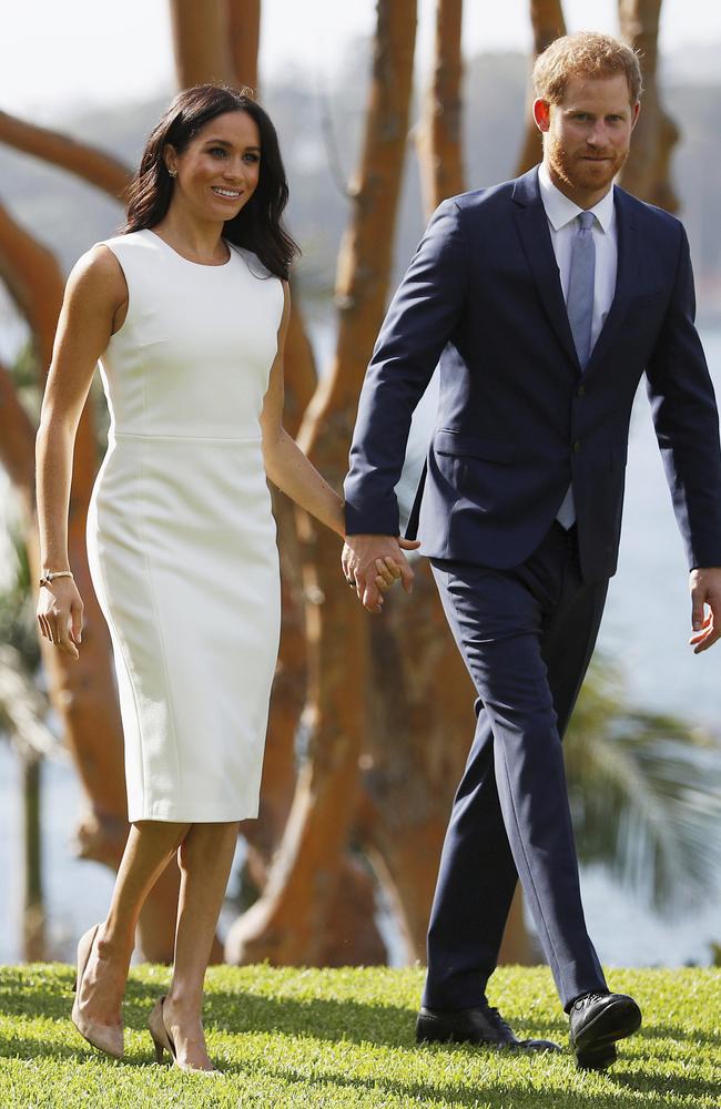 The expectant couple hold hands as they walk on the lawns at Admiralty House. Picture: Phil Noble/AP