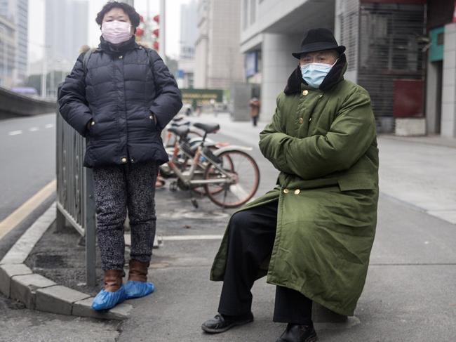 Two residents wear protective masks in Wuhan, China. The city remains in lockdown. Picture: Getty Images