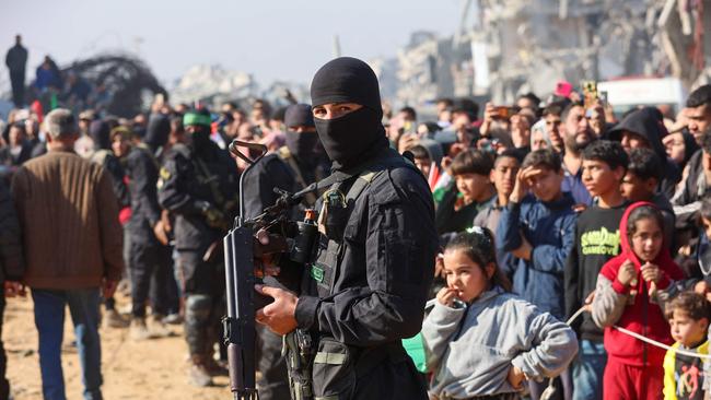 A Hamas militant stands guard near a stage as Gazans gather to watch the release of Israeli hostage Agam Berger to a Red Cross team in Jabalia on January 30, 2025, as part of their third hostage-prisoner exchange.