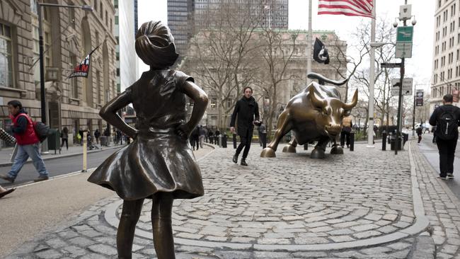 A statue titled “Fearless Girl” faces the Wall Street bull, Wednesday, March 8, 2017, in New York, to mark International Women’s Day. Picture: Mark Lennihan/AP