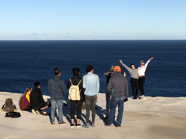 Tourist strike a pose, while risking disaster. Picture: KHAPGG/MEGA