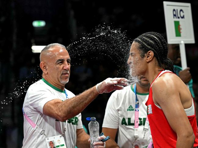 Algeria's Imane Khelif (in red) arrives for her women's 66kg preliminaries round of 16 boxing match against Italy's Angela Carini during the Paris 2024 Olympic Games at the North Paris Arena, in Villepinte on August 1, 2024. (Photo by MOHD RASFAN / AFP)