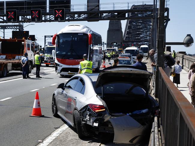 Pedestrians (right side of picture) pass the crash scene. Picture: Richard Dobson