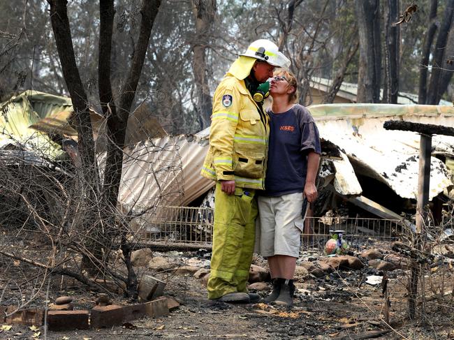 Gary Greene and his partner Kim Macdonald at their burnt out home in Bobin. Picture Nathan Edwards