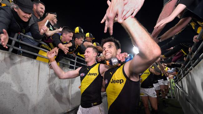 Dylan Grimes and Trent Cotchin hi-five fans after their Qualifying Final win. Picture: Bradley Kanaris