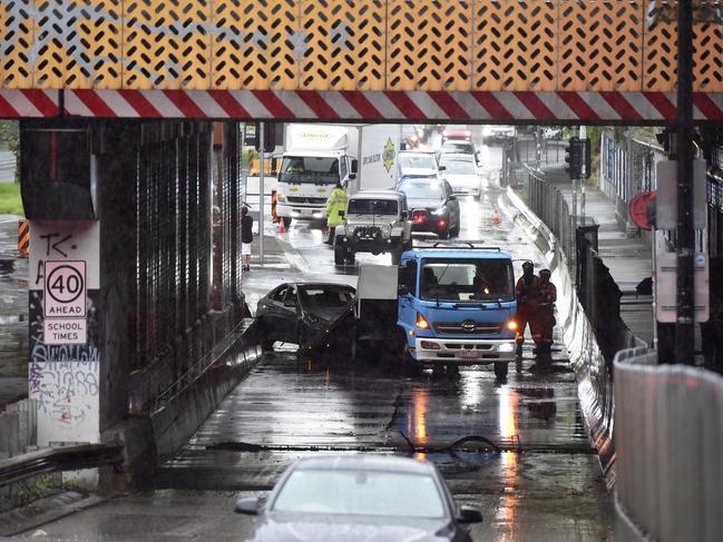 Emergency services retrieve a submerged car that had been caught in flood waters under the Dudley Street rail overpass at West Melbourne. Picture: NCA NewsWire / Andrew Henshaw