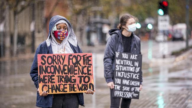 Protesters hold slogans at today’s Black Lives Matter gathering in Victoria Square. Photo: MIKE BURTON