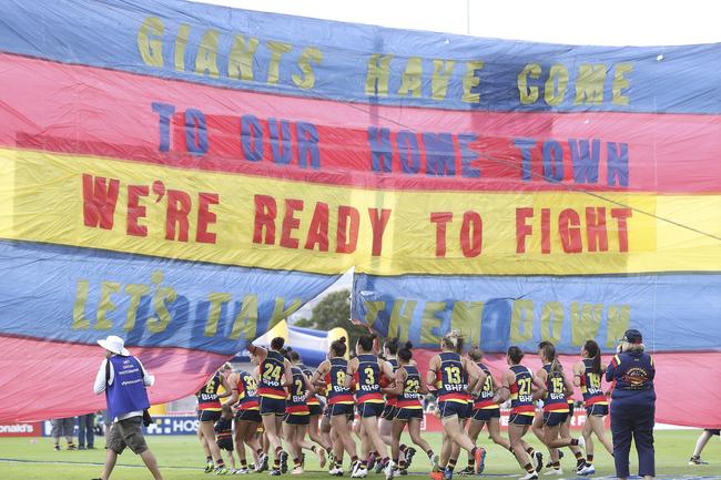 Crows AFLW players run through the banner at Peter Motley Oval. Picture Sarah Reed