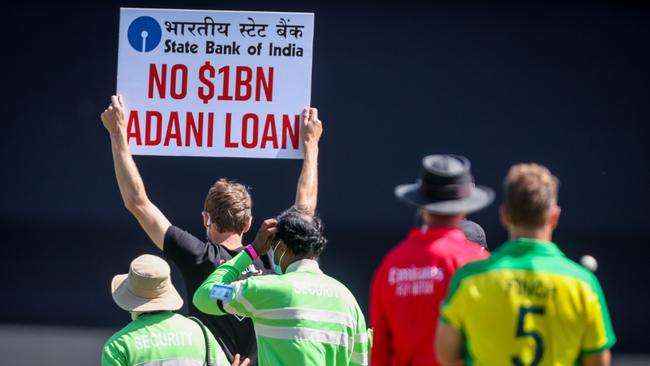 One of the protesters is escorted off the SCG. Picture: AFP