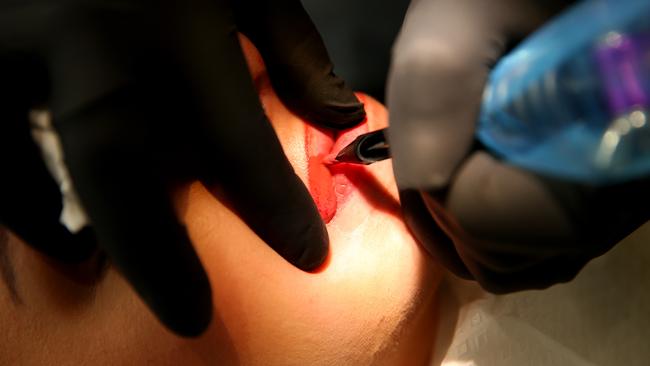 Owner Rita Porreca lip tattoos a patient.                         Picture: Justin Sanson