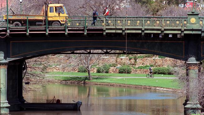 Adelaide City council workers watching diver recover missing section of the River Torrens bridge near the Zoo.