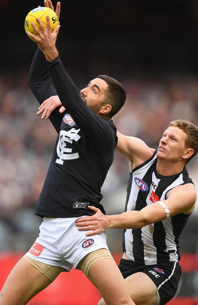 Kade Simpson marks in front of Magpie Will Hoskin-Elliott.