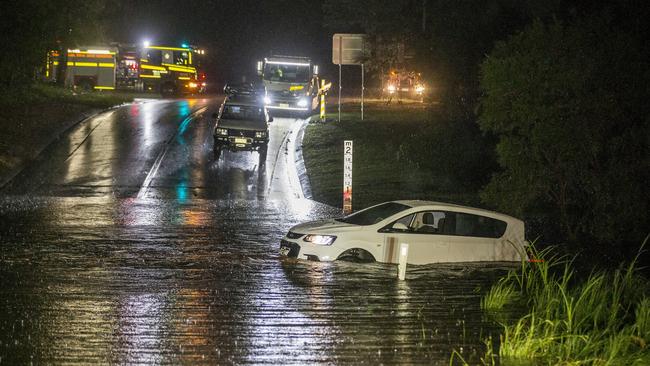 A vehicle is stranded on a bridge in the water along Hardys Rd, Bonogin on Friday night. Picture: Jerad Williams