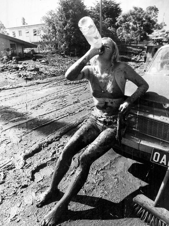 : Refreshing soft drink for mud splattered worker Jackie Gray of Red Hill. Jackie was helping clean up in Ormadale Road, Yeronga, after the Brisbane floods. Picture by Ted Holliday