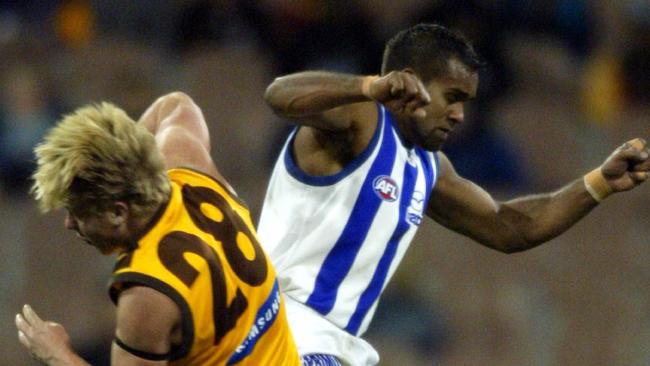 Sam Mitchell, in his first year with the Hawks, cops a bump from Kangaroo Byron Pickett in 2002.