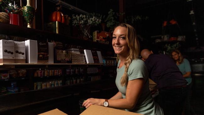 Heather Haines from Parap Fine Foods moves perishable items from the business’ in-store fridge to back-up fridge to save stock. Picture: Che Chorley