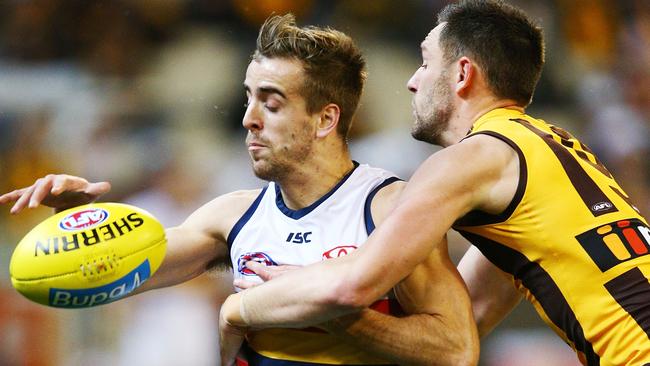 Young Crow Jordan Gallucci gets the ball away under pressure from Jack Gunston of the Hawks. Picture: Michael Dodge/Getty Images