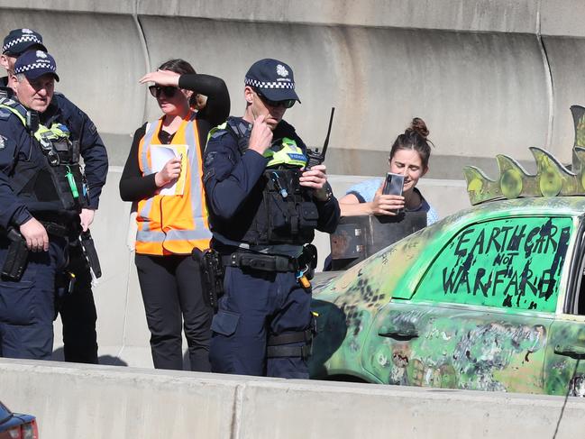 The woman live-streams the incident while surrounded by police. Picture: David Crosling