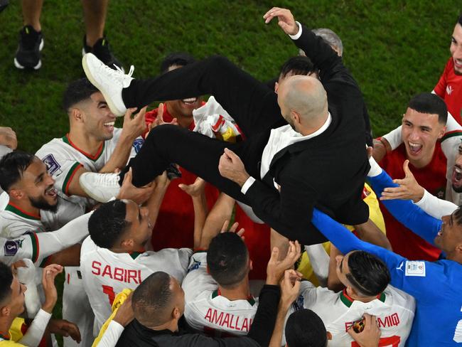 Morocco players celebrate with Morocco's coach Walid Regragui (C) after they won the Qatar 2022 World Cup Group F football match between Canada and Morocco. Picture: Antonin Thuillier/AFP