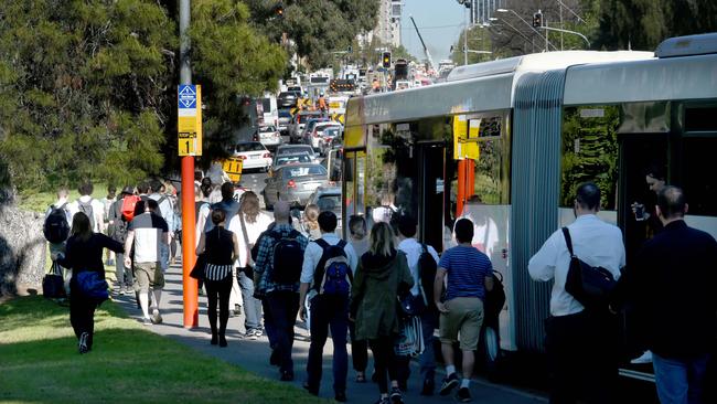 Commuters give up on the bus and walk into the city during another traffic jam caused by the tram line extension along North Terrace. Picture: Tricia Watkinson