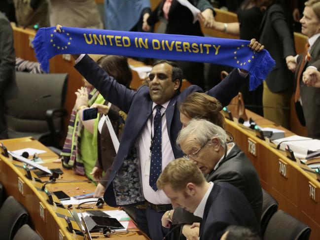 Parliamentarians applaud and hold up banners after a vote on the UK's withdrawal from the EU. Picture: AP