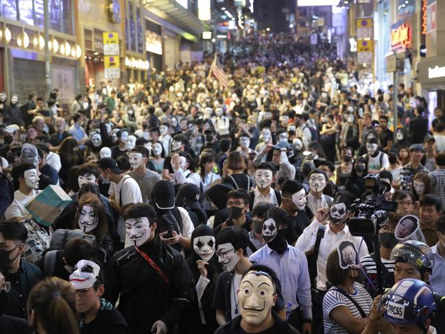 People wearing masks gather on a street in Hong Kong. Picture: AP Photo/Kin Cheung