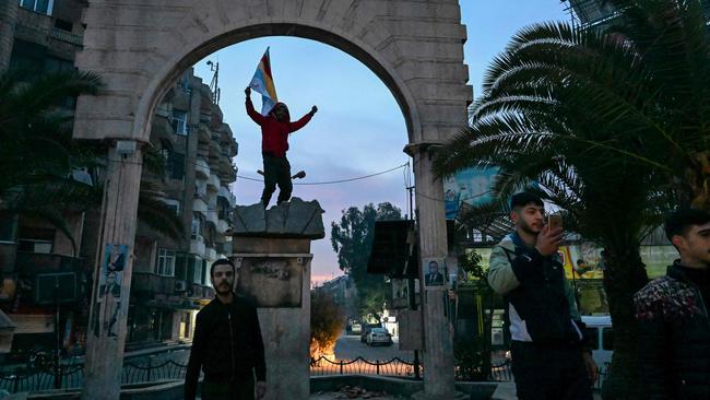 Local residents cheer as they gather on a street in the Damascus suburb of Jaramana. Picture: AFP