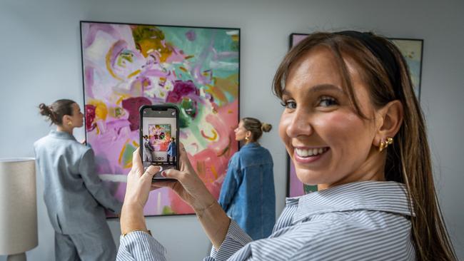 The Real Estate Stylist is a property styling company based in Melbourne. They use Instagram to promote their work. Jordy Mai and Elyce Cinerari hang a picture while Molly Tilbury-Leahy films for Instagram. Picture: Jake Nowakowski