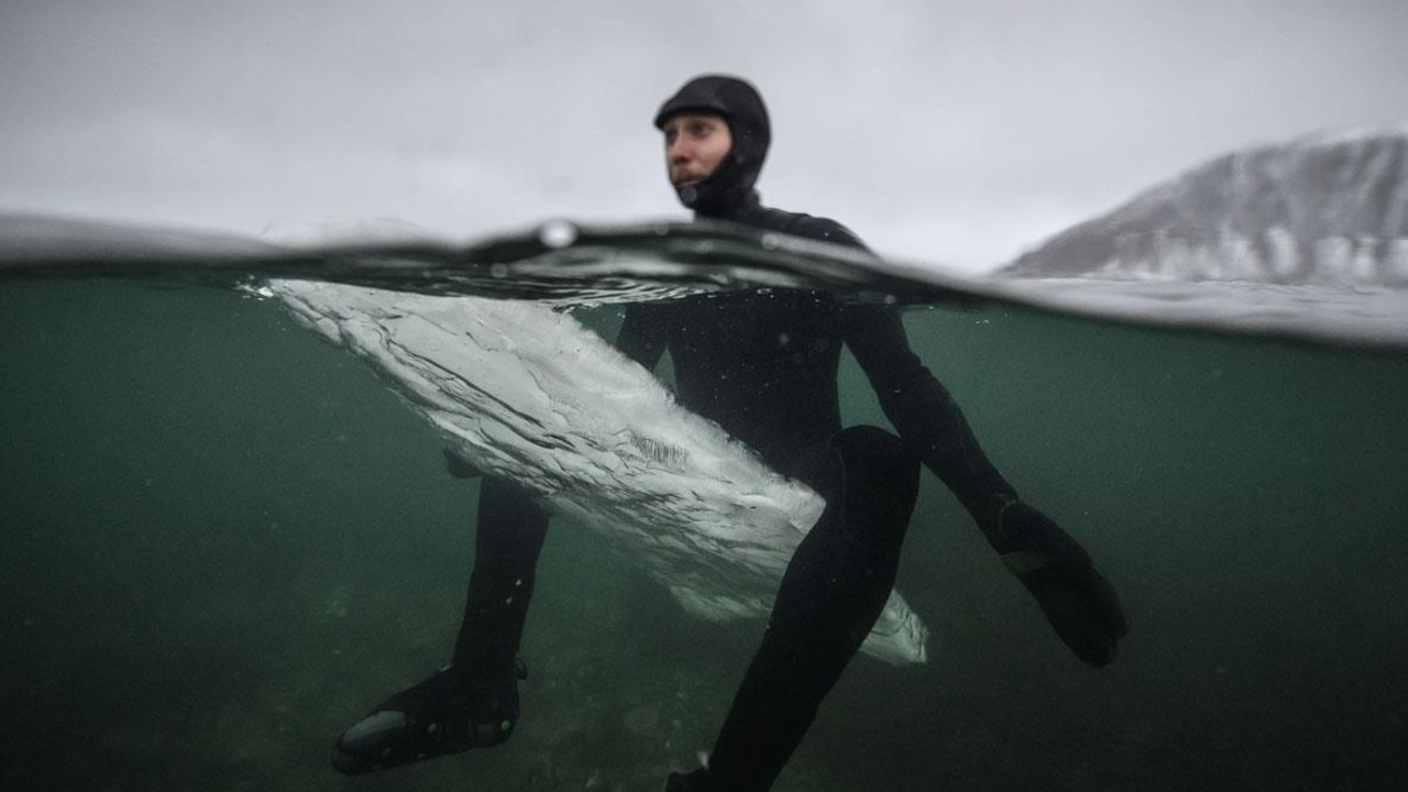 Swedish surfer Pontus Hallin waits for waves as he sits on his melting ice surfboard at the Delp surfing spot, near Straumnes, in the Lofoten Islands. Picture: AFP/Olivier Morin