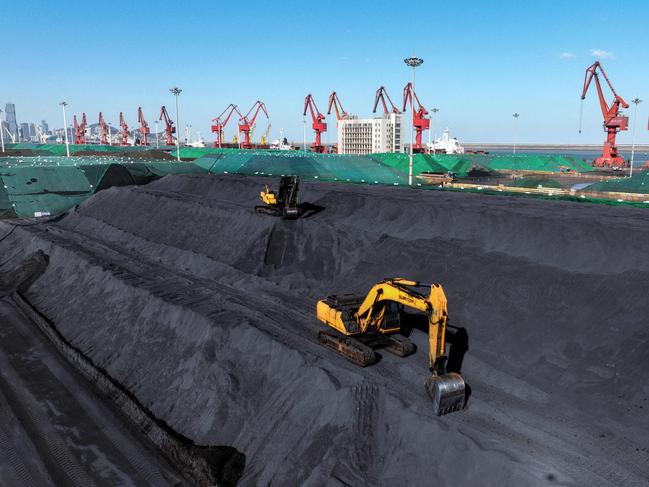 (FILES) Excavators transfer coal at the coal terminal of Lianyungang Port in Lianyungang, in China's eastern Jiangsu province on January 22, 2024. China last year began construction on projects with the greatest combined coal power capacity since 2015, jeopardising the country's goal to peak carbon emissions by 2030, according to a report published on February 13, 2025. (Photo by AFP) / China OUT